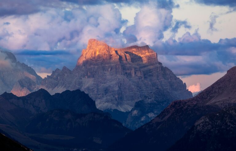 Sunlit mountain peak against dramatic clouds