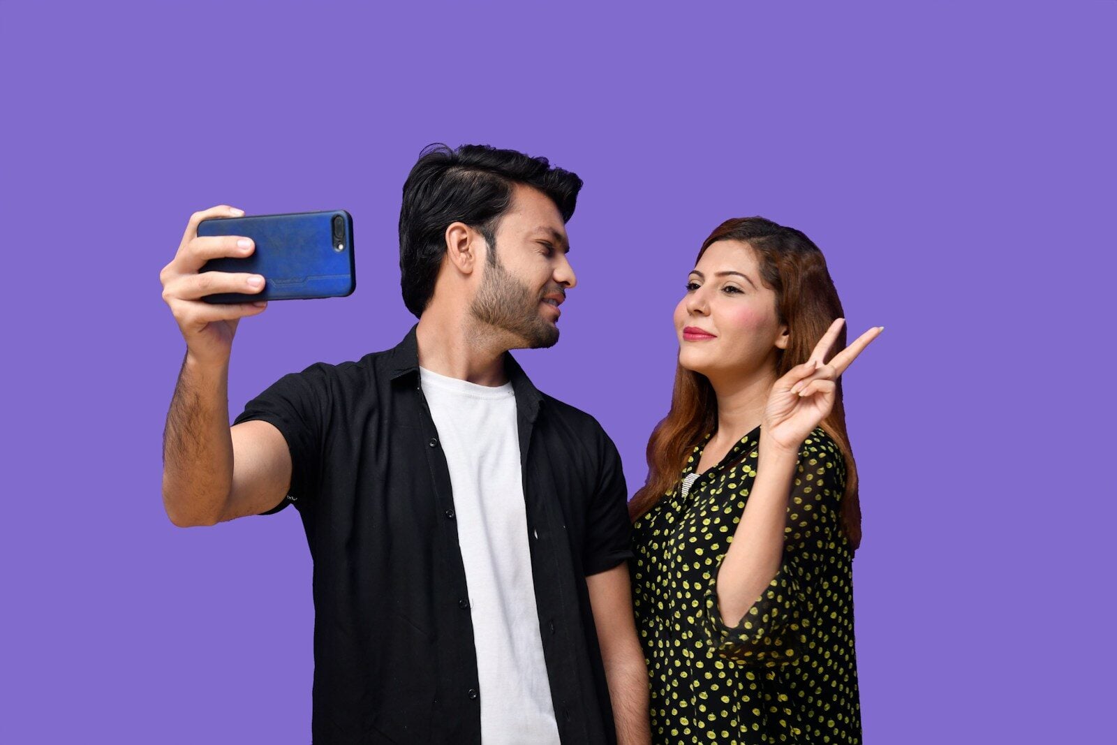 a man and woman holding a phone
